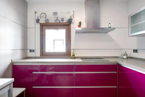 uma cozinha com armários roxos e uma janela em Reina's em Vejer de la Frontera