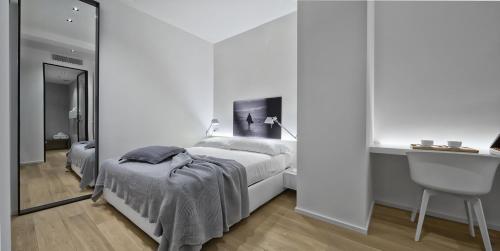 a white bedroom with a bed and a sink at Luxury Suites Collection - SHANTUNG Double Room in Riccione