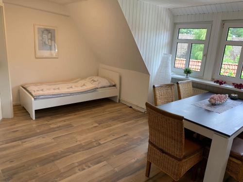 um quarto com uma cama, uma mesa e cadeiras em Monteurwohnungen Visselhövede em Visselhövede