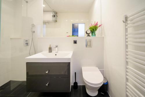 a white bathroom with a sink and a toilet at Maya's Flats & Resorts 63 - 3 rooms flat in old town Gdansk in Gdańsk