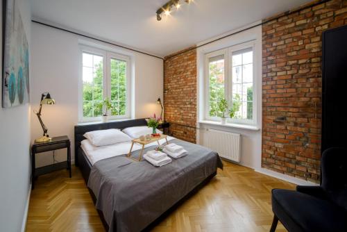 ein Schlafzimmer mit einem Bett und einer Ziegelwand in der Unterkunft Maya's Flats & Resorts 63 - 3 rooms flat in old town Gdansk in Danzig