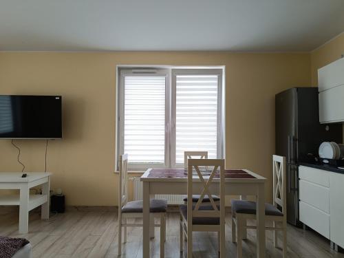 a kitchen with a table and chairs and a window at Apartament Rodzinny in Oława