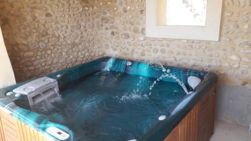 un baño con una bañera con agua saliendo de ella en Chambre à la ferme au milieu des lavandes, en Valensole