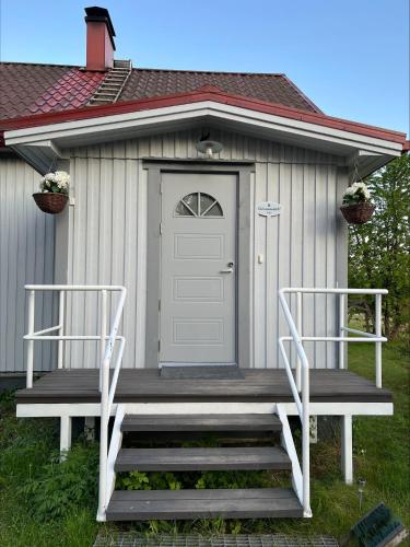 a shed with a door and two chairs in front of it at Villa Taivaanvuohi in Kyrö