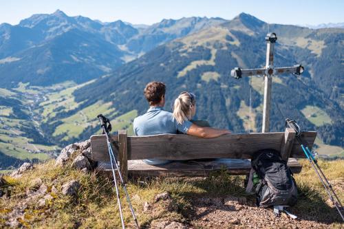 a couple sitting on a bench on top of a mountain at Chalet Innertal in Inneralpbach