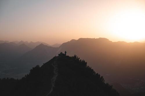 a person standing on top of a mountain at sunset at Chalet Innertal in Inneralpbach
