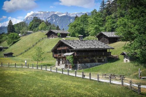 阿爾卑巴赫的住宿－Chalet Innertal，一座带围栏的山丘上的古老木结构建筑