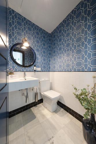 a bathroom with a toilet and a sink and a mirror at nüa cicerone in Seville