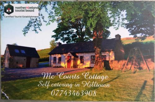 a picture of a house with a tree at Mc Courts Cottage & Barn in Newry