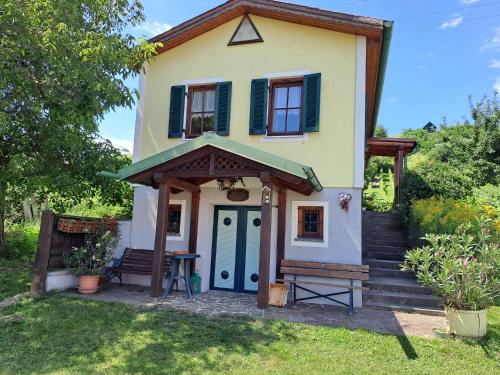 a small yellow house with a blue door at Kellerstöckl Berta in Eisenberg an der Pinka