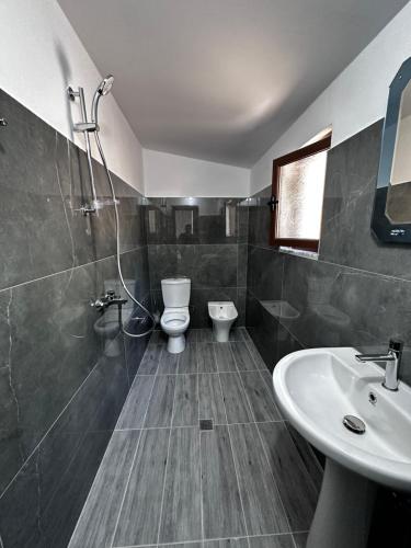 a bathroom with a toilet and a sink at Guest House Sakollari in Poliçan