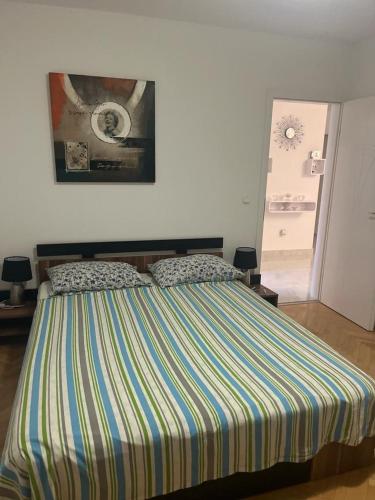 a bedroom with a bed with a striped blanket at Apartment Thomy in Medulin