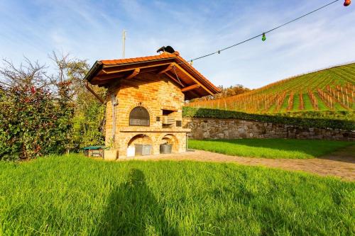 a small stone building in a field of grass at Schwarzwaldtraum am Weinberg in Sasbachwalden
