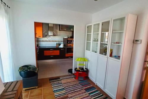 a kitchen with white cabinets and a childs toy in it at Casa del Río in Móstoles