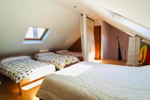 a attic bedroom with two beds and a window at Casa del Río in Móstoles