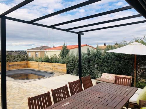 a patio with a table and chairs and a pool at Casa del Río in Móstoles