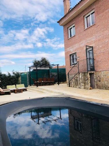 a pool of water in front of a brick building at Casa del Río in Móstoles