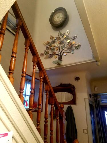une horloge sur le mur à côté d'un escalier dans l'établissement Villa Normandy, à Gagny