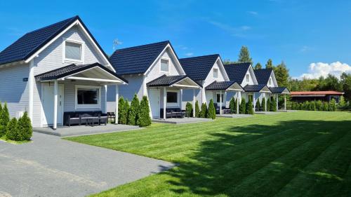 szereg domów z zielonym trawnikiem w obiekcie Domki na Żytniej w mieście Kopalino