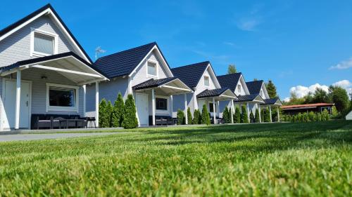 a row of houses with a green lawn at Domki na Żytniej in Kopalino