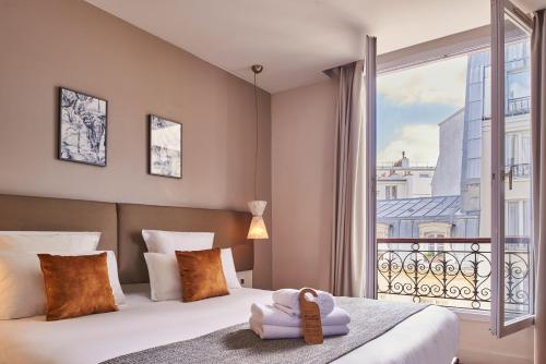 a bedroom with a bed and a large window at Hotel Magenta 38 by Happyculture in Paris