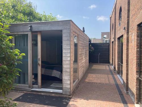 a small black shed in a courtyard between two buildings at Tuinhuis aan het water in Voorburg