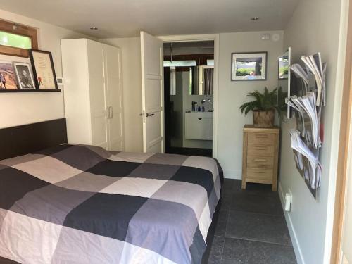a bedroom with a large bed and a bathroom at Tuinhuis aan het water in Voorburg