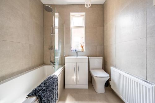 a bathroom with a toilet and a sink and a window at Luxury Liverpool Accommodation in Liverpool