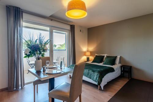 - une chambre avec un lit, un bureau et une table avec un ordinateur portable dans l'établissement OVELIA Seynod - Les Balcons d'Annecy, à Annecy