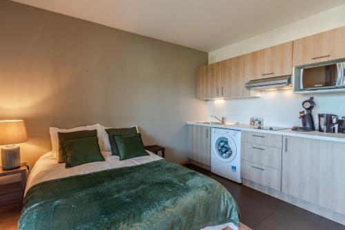 une petite chambre avec un lit et une cuisine dans l'établissement OVELIA Seynod - Les Balcons d'Annecy, à Annecy