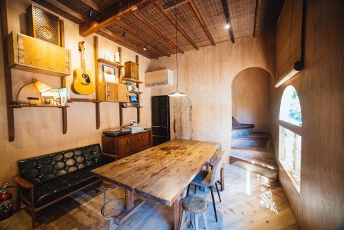 a dining room with a wooden table and a couch at Villa Yumigahama in Minamiizu
