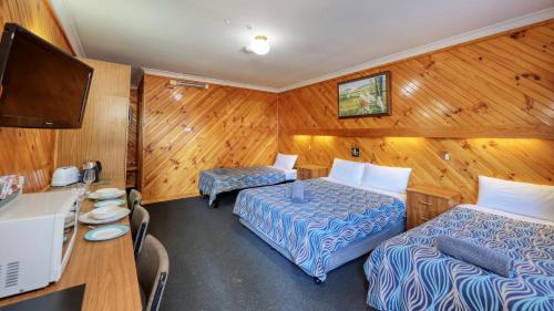 a hotel room with two beds and a desk at Darling River Motel in Bourke