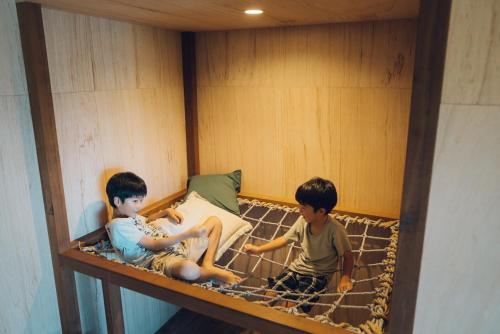 two young boys sitting in a bunk bed at Villa Yumigahama in Minamiizu