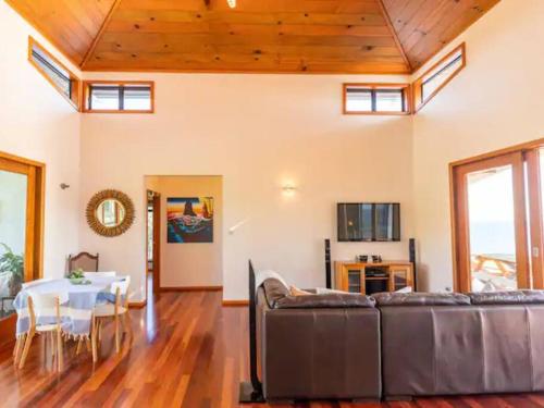 a living room with a couch and a table at King Tide House - Ocean Views in Burnt Pine