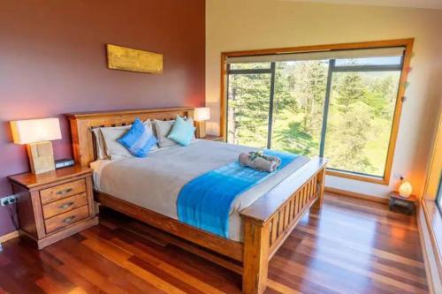 a bedroom with a large bed and a large window at King Tide House - Ocean Views in Burnt Pine