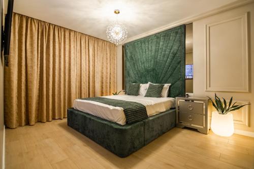 a bedroom with a bed with a green headboard at The 502 Mamaia in Mamaia