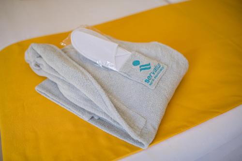 a pair of towels sitting on a yellow plate at Servatur Waikiki in Playa del Ingles