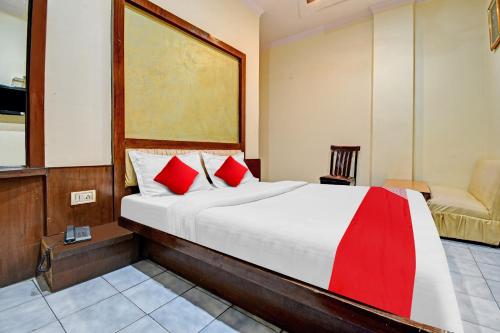 a bedroom with a large bed with red pillows at Flagship S S G Residency in Mysore