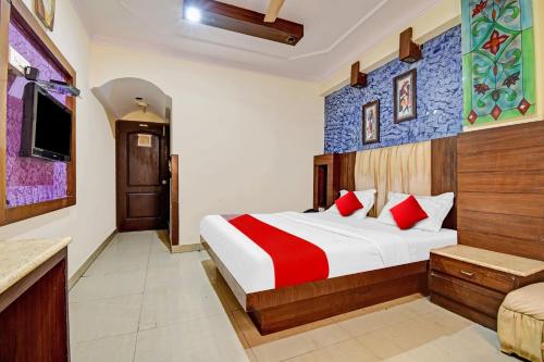 a hotel room with a bed with red pillows at Flagship S S G Residency in Mysore