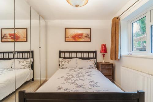 桑尼戴爾的住宿－LARGE COSY HOME @ WENTWORTH, SUNNINGDALE, ASCOT，一间卧室设有两张床和窗户。