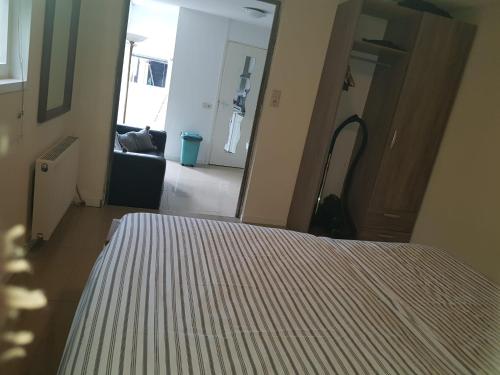 um quarto com uma cama com um edredão listrado em La Luna - Desi em Heerhugowaard