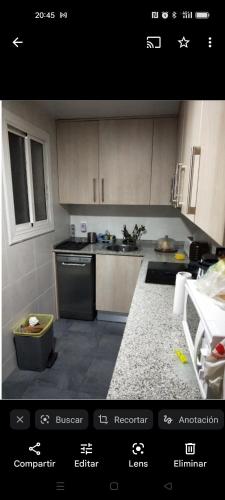 巴達洛納的住宿－Habitación individual con cama supletoria.，厨房配有白色橱柜和炉灶烤箱。