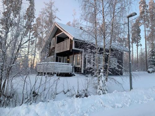 uma cabana de madeira na neve na floresta em Riihipeikko Jyväskylän läheisyydessä Muuramen Riihivuoressa em Muurame