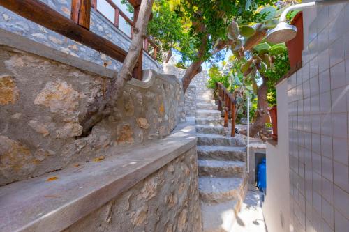 a stone wall with stairs next to a building at Faraglionensis MonaconeHouse Villa in Capri