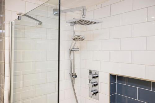 a shower in a bathroom with white tiles at JOIVY Splendid 2bed apt near Haymarket in Edinburgh