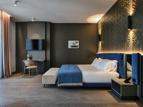 ストレーザにあるBoutique Hotel Stresaのベッドとデスクが備わるホテルルームです。