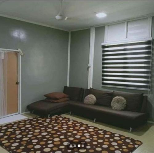 uma sala de estar com um sofá e um tapete em Homestay Murah Orkid em Tumpat