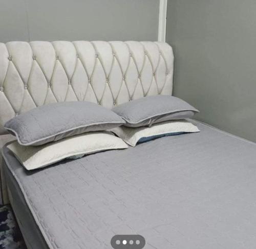 uma cama com almofadas e uma cabeceira branca em Homestay Murah Orkid em Tumpat