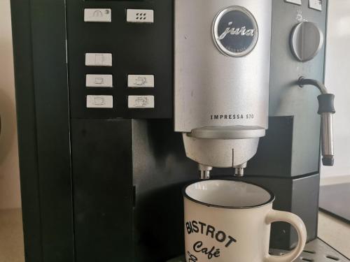 a coffee machine with a cup on a counter at Stunning new design apartment next to park in Chişinău