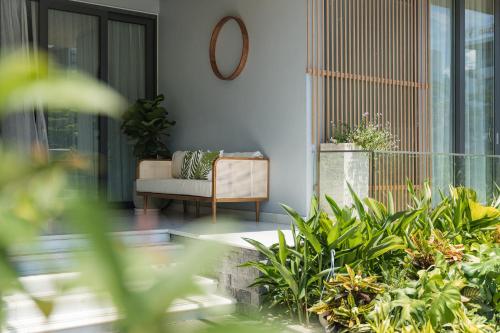 - un salon avec un canapé et des plantes dans l'établissement Tahagi Villa Tuan Chau Ha Long, à Hạ Long